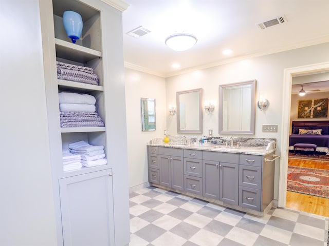 bathroom featuring built in features, vanity, and ornamental molding