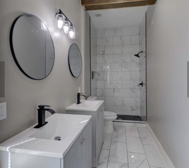 bathroom featuring tiled shower, vanity, and toilet