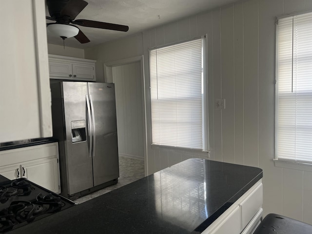 kitchen with a wealth of natural light, stainless steel refrigerator with ice dispenser, white cabinetry, and ceiling fan