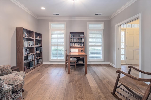 living area with crown molding, a wealth of natural light, and light hardwood / wood-style flooring