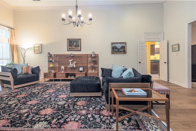 living room with crown molding, hardwood / wood-style floors, and a notable chandelier