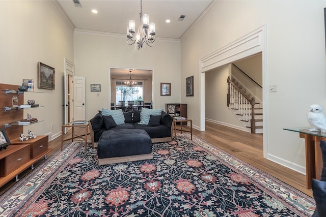 living room featuring crown molding, hardwood / wood-style floors, and a chandelier