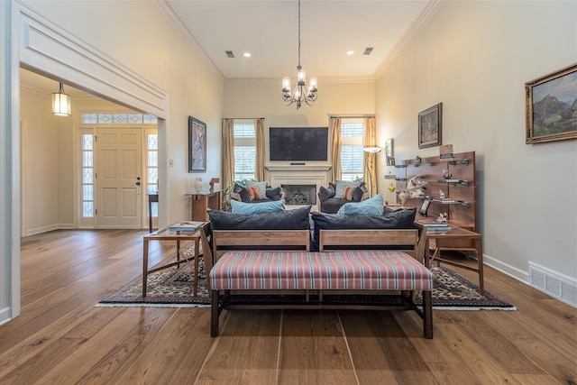 living room with crown molding, hardwood / wood-style flooring, and a chandelier