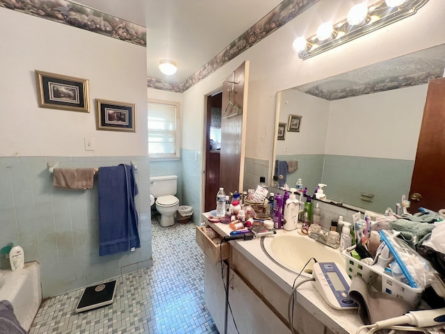 bathroom featuring tile patterned flooring, vanity, tile walls, and toilet