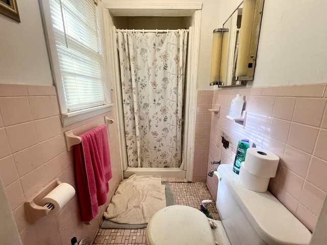 bathroom with a shower with shower curtain, toilet, tile walls, and tile patterned floors