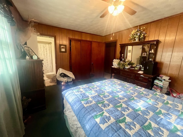 bedroom featuring ceiling fan, wooden walls, a textured ceiling, and dark colored carpet