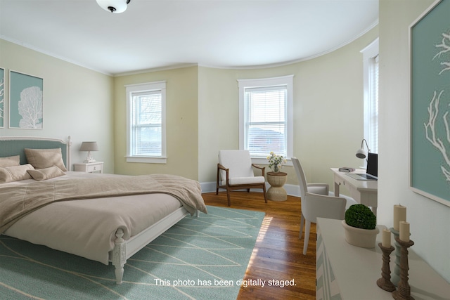 bedroom with hardwood / wood-style floors, crown molding, and multiple windows