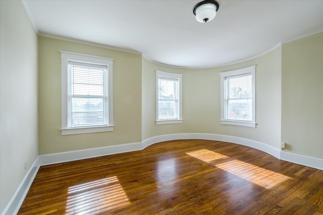 unfurnished room with crown molding, a wealth of natural light, and dark wood-type flooring