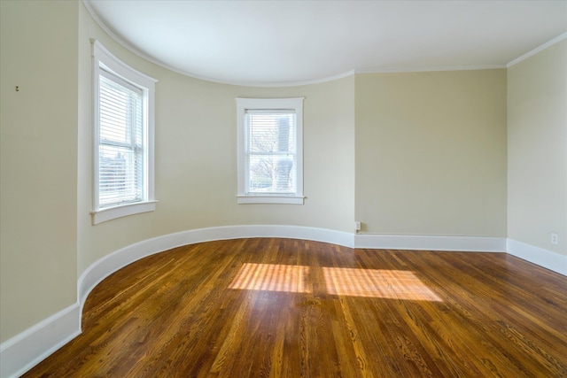 unfurnished room featuring crown molding, a wealth of natural light, and dark wood-type flooring