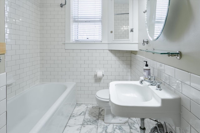 bathroom featuring toilet, tile walls, and sink