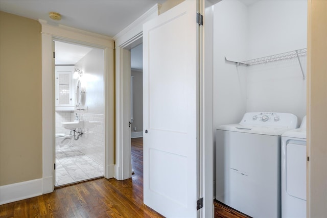 laundry room with dark hardwood / wood-style flooring, washer and clothes dryer, and sink