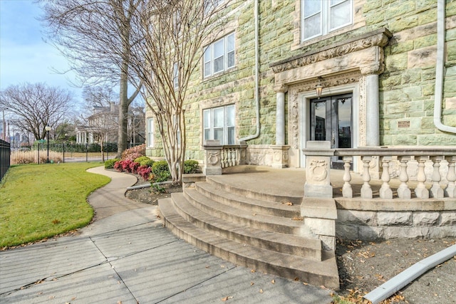 property entrance with a lawn and french doors