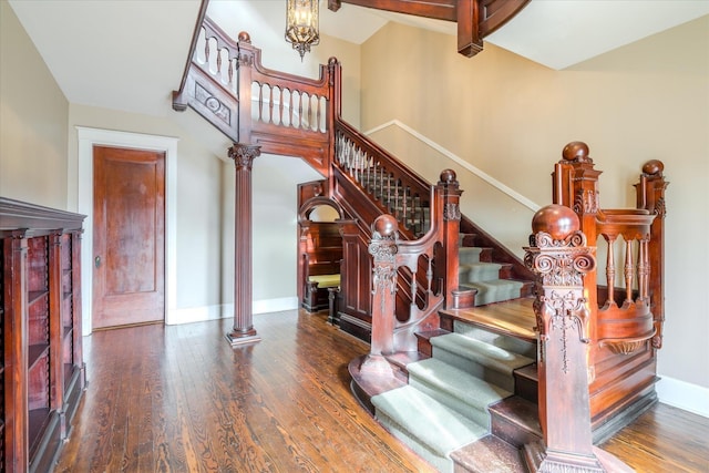 stairway featuring hardwood / wood-style floors and decorative columns