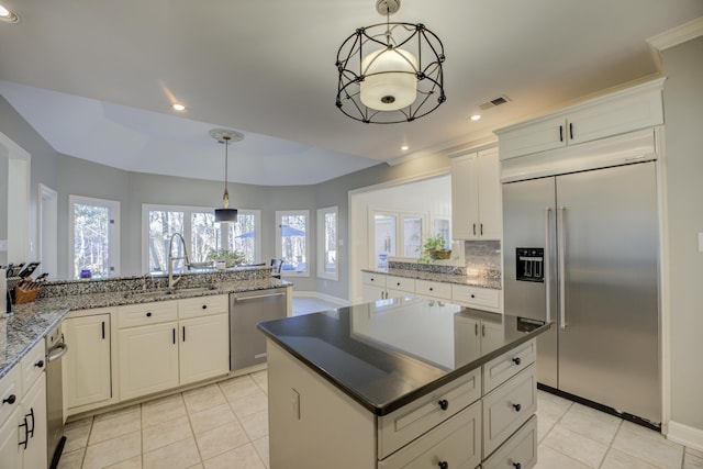 kitchen featuring pendant lighting, sink, appliances with stainless steel finishes, white cabinetry, and kitchen peninsula