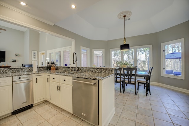 kitchen with dishwasher, light stone counters, white cabinetry, and a tray ceiling