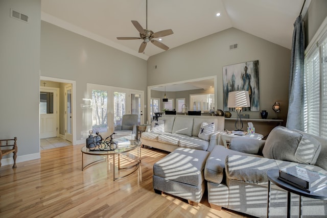 living room with ceiling fan, high vaulted ceiling, and light hardwood / wood-style flooring