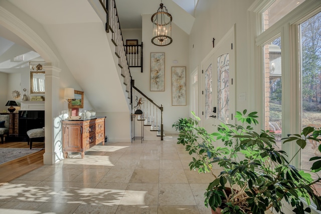 foyer with ornamental molding, lofted ceiling, and a notable chandelier