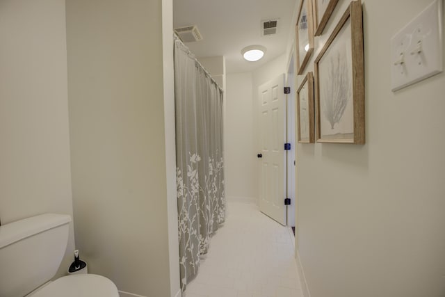 bathroom with curtained shower and toilet