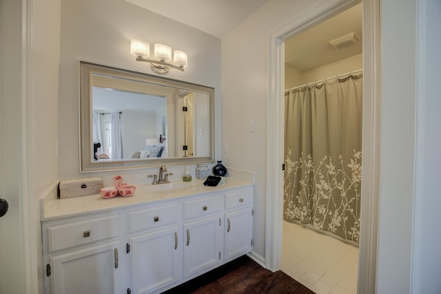 bathroom featuring wood-type flooring, vanity, and curtained shower