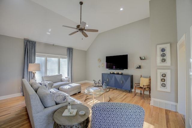 living room with hardwood / wood-style flooring, vaulted ceiling, and ceiling fan