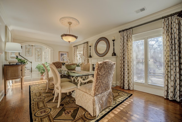 dining space featuring plenty of natural light, wood-type flooring, and ornamental molding