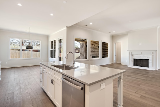 kitchen featuring pendant lighting, white cabinets, a center island with sink, sink, and stainless steel dishwasher