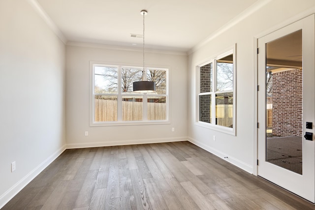 unfurnished dining area with wood-type flooring and crown molding