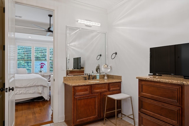 bathroom with hardwood / wood-style flooring, vanity, ceiling fan, and ornamental molding