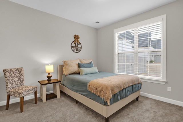 bedroom with multiple windows and light colored carpet