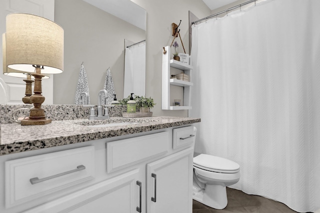 bathroom with tile patterned flooring, vanity, and toilet