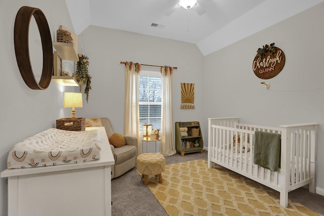 bedroom featuring lofted ceiling, ceiling fan, light carpet, and a crib