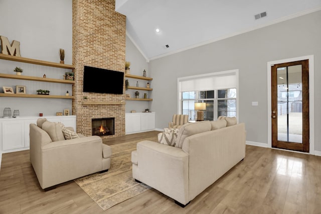 living room with high vaulted ceiling, light hardwood / wood-style flooring, a brick fireplace, and ornamental molding