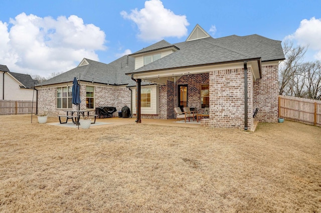 back of house with a patio area and a yard