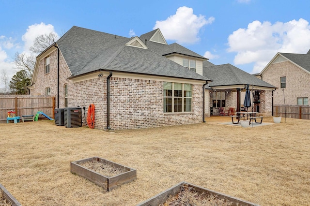 rear view of property with a yard, cooling unit, and a patio area