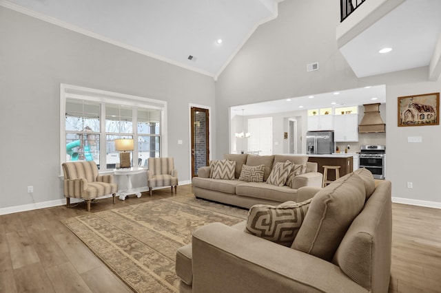 living room with crown molding, light hardwood / wood-style flooring, high vaulted ceiling, and a chandelier