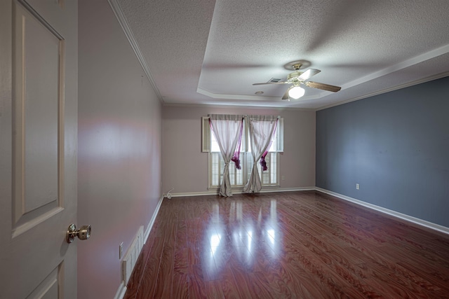 spare room featuring ornamental molding, a textured ceiling, a tray ceiling, ceiling fan, and hardwood / wood-style floors