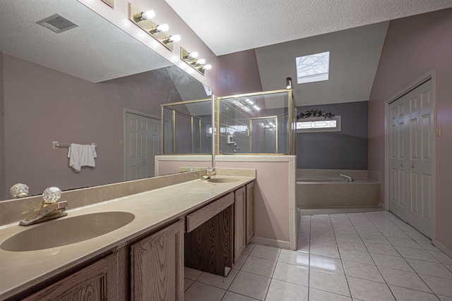 bathroom with tile patterned flooring, vanity, a textured ceiling, and a skylight