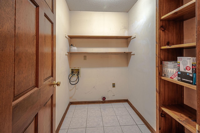 laundry area with washer hookup, a textured ceiling, light tile patterned floors, and electric dryer hookup