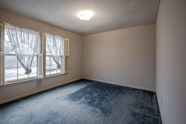 carpeted empty room featuring a textured ceiling