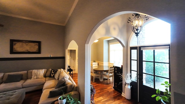 living room featuring an inviting chandelier, high vaulted ceiling, and hardwood / wood-style floors