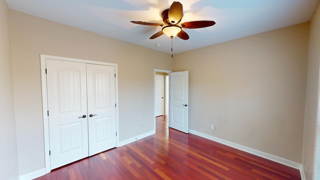 unfurnished bedroom featuring dark hardwood / wood-style flooring, a closet, and ceiling fan