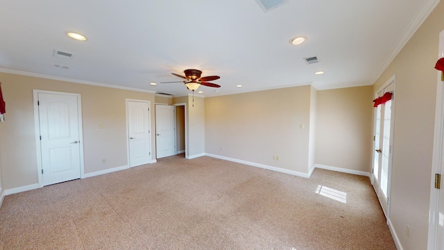 unfurnished bedroom featuring ceiling fan, light carpet, two closets, and ornamental molding