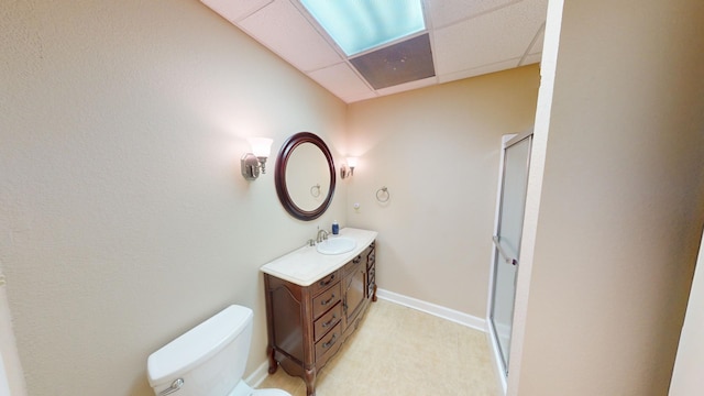 bathroom with a paneled ceiling, vanity, and toilet