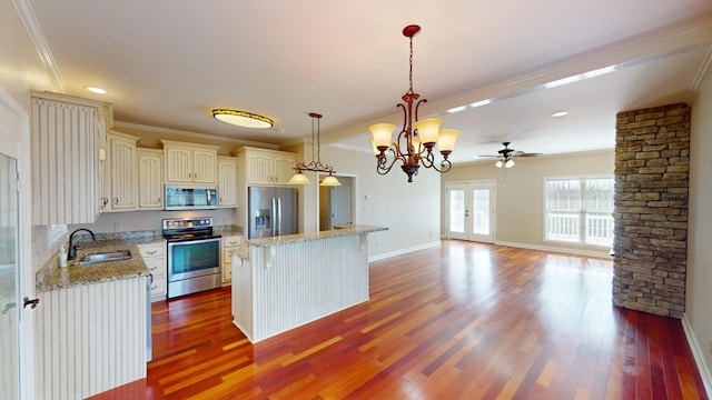 kitchen featuring a center island, sink, crown molding, decorative light fixtures, and stainless steel appliances