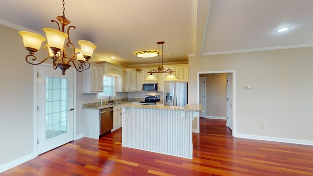 kitchen with sink, an inviting chandelier, decorative light fixtures, appliances with stainless steel finishes, and ornamental molding