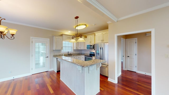 kitchen featuring a center island, sink, hanging light fixtures, ornamental molding, and stainless steel appliances