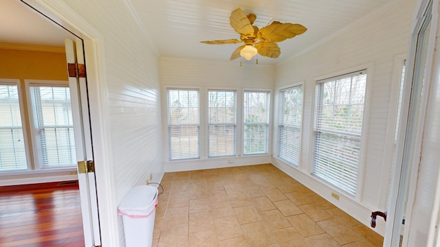 unfurnished sunroom featuring ceiling fan