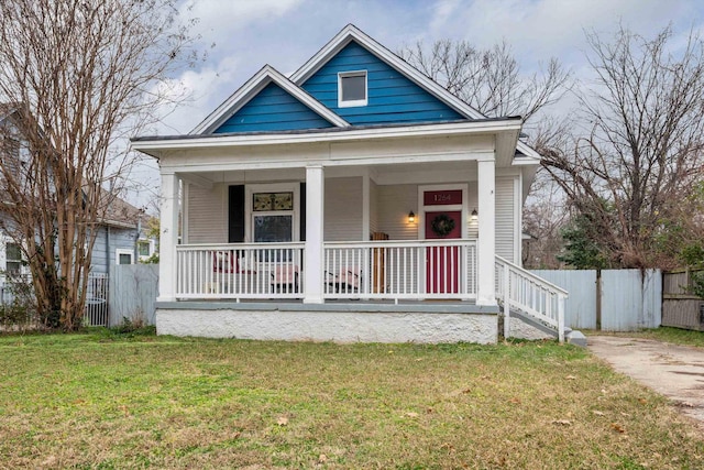 view of front of home with fence, a porch, and a front yard