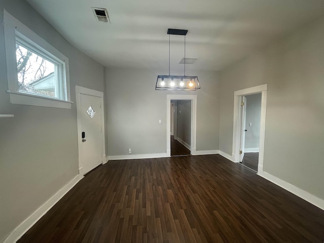 unfurnished dining area with dark wood finished floors, visible vents, and baseboards