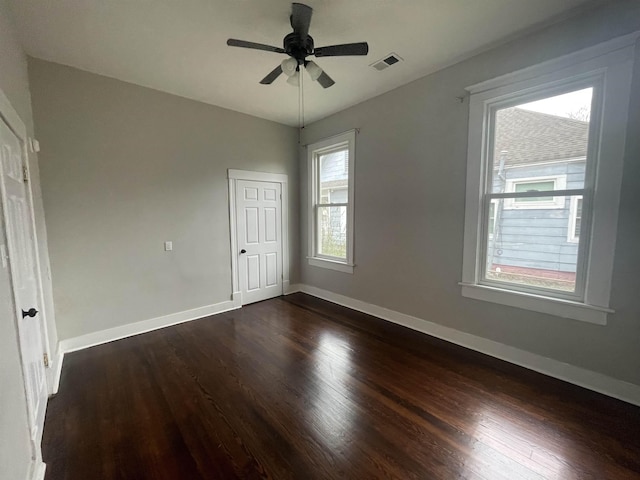 unfurnished bedroom with visible vents, baseboards, ceiling fan, and dark wood-type flooring